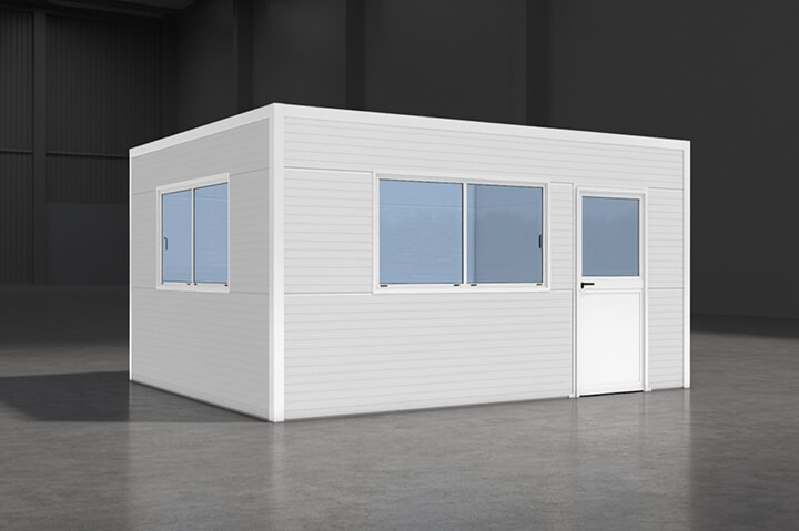 White prefabricated modular office with smooth panels, large blue‑tinted windows, and a door, placed inside an industrial warehouse with concrete flooring and high ceilings.